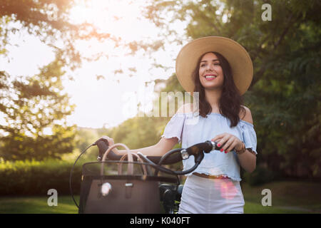 Porträt der schöne junge Frau auf dem Fahrrad genießen. Stockfoto