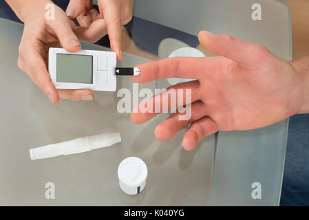 In der Nähe der weiblichen Arzt mit lanzettfischchens auf Mann am Schreibtisch, In der Klinik Stockfoto