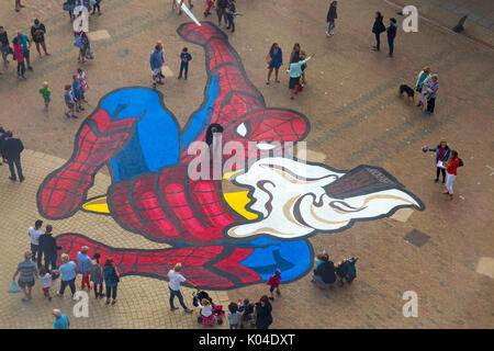 Auf der Suche nach Spiderman Cover mit Menschen Gefühl der Skala am Pier Ansatz, Bournemouth, Dorset, UK im August - von Ambassadeur Kunst arrangiert zu zeigen Stockfoto