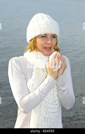 Hübsche blonde Frau mittleren Alters in einem Herbst Spaziergang an einem See. Stockfoto