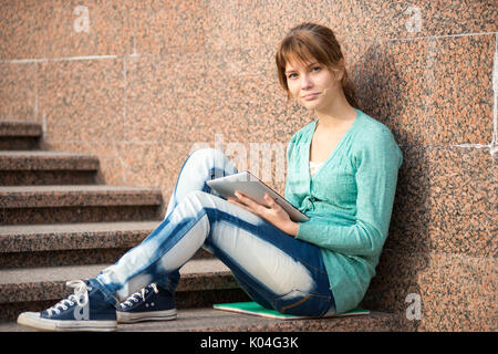 Schöne junge Studentin mit Notizblock. Outdoor-Student. Stockfoto