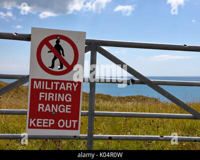 In den Fuß geschossen? Ganz in der Nähe! Militärische Warnschild mit Einschusslöchern sauber durch erhebliche Metall farm gate Bars, Dorset UK Stockfoto