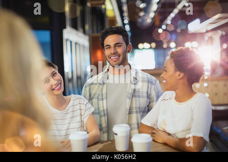 Lächelnden jungen Freunde trinken Kaffee im Cafe Stockfoto