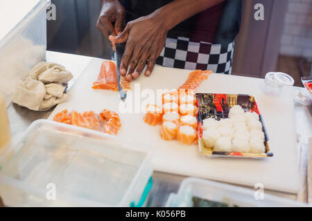 Junge Köchin Schneiden von Lachs, Sushi im Restaurant Stockfoto