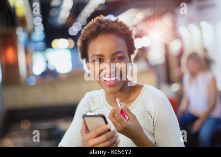 Portrait lächelnden jungen Frau Anwendung Lippenstift Stockfoto