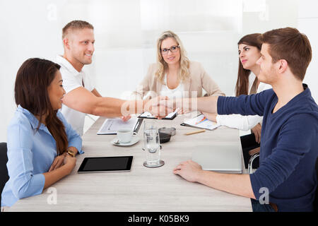 Geschäftsleute Händeschütteln treffen am Schreibtisch Stockfoto