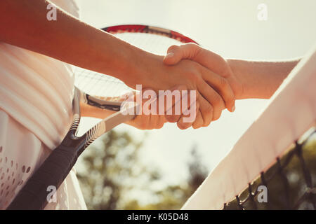 In der Nähe Tennis Spieler handshaking in sportsmanship im Net Stockfoto