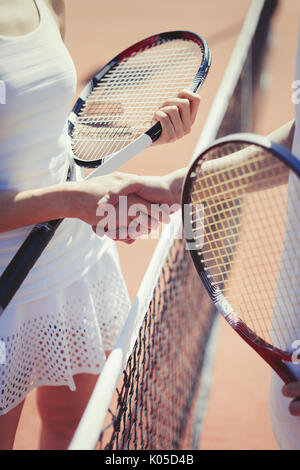 Tennis Spieler handshaking in sportsmanship im net an sonnigen Tennisplatz Stockfoto