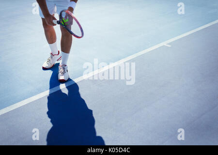 Jungen männlichen Tennisspieler vorbereiten, die Kugel auf sonnigen blauen Tennisplatz zu dienen Stockfoto