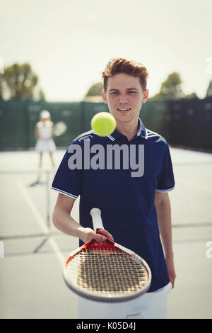 Junge männliche tennis player Tennis ball Aufprallen auf Tennisschläger auf Tennisplatz Stockfoto
