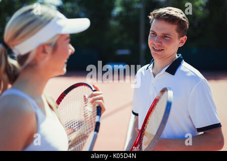 Männliche und weibliche Tennisspieler sprechen, holding Tennisschläger Stockfoto