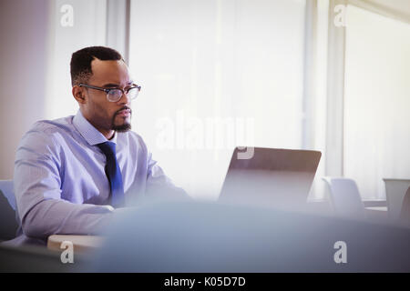Ernsthafte Geschäftsmann mit Laptop im Konferenzraum Stockfoto
