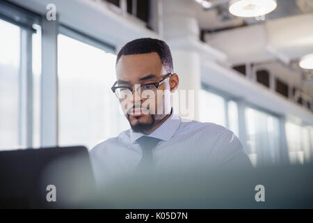 Ernst, fokussierte Geschäftsmann arbeiten am Laptop im Büro Stockfoto