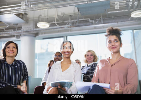 Lächelnd, aufmerksam Geschäftsfrau hören in Konferenz Publikum Stockfoto