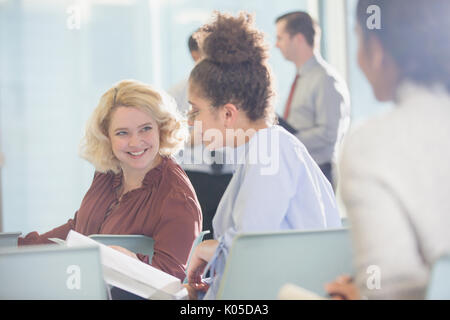 Geschäftsfrauen Unterlagen darüber beraten in der Konferenz Publikum Stockfoto