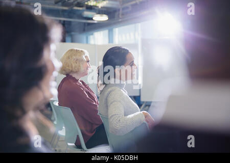 Lächelnde Geschäftsfrauen in Konferenz Publikum hören Stockfoto