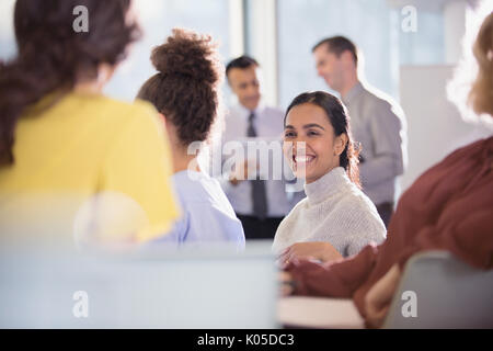 Lächelnd Geschäftsfrau im Gespräch mit Kollegen in der Konferenz Publikum Stockfoto