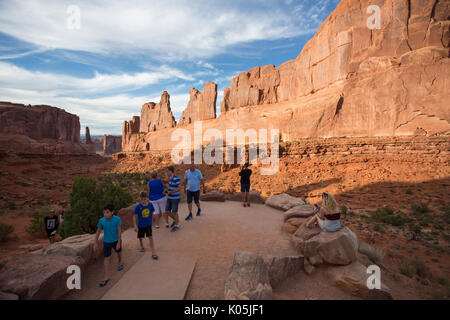 Touristen Spaziergang durch die bewachsene Wüste, von der Sonne von Sonnenschirmen auf der Insel im Himmel, Canyon lands National Park, Utah, USA geschützt. Stockfoto