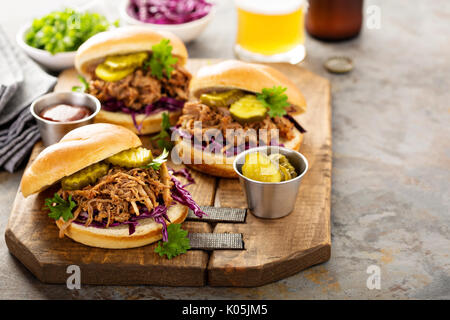 Gezogene Schweinefleischsandwiche mit Kohl und Gurken Stockfoto