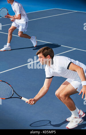 Entschlossene junge Mann Tennis Doubles Spieler mit Tennisschläger auf Tennisplatz balanciert Stockfoto