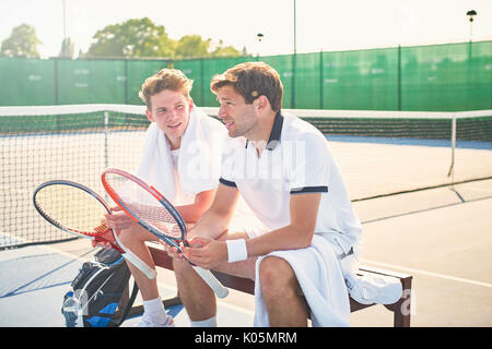 Jungen männlichen Tennisspieler ruht mit Tennisschläger an sonnigen Tennisplatz Stockfoto