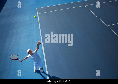 Ansicht von oben jungen männlichen Tennisspieler Tennis spielen, in der die Kugel auf sonnigen blauen Tennisplatz Stockfoto