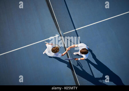 Ansicht von oben jungen männlichen Tennisspieler handshaking im Net auf sonnigen blauen Tennisplatz Stockfoto