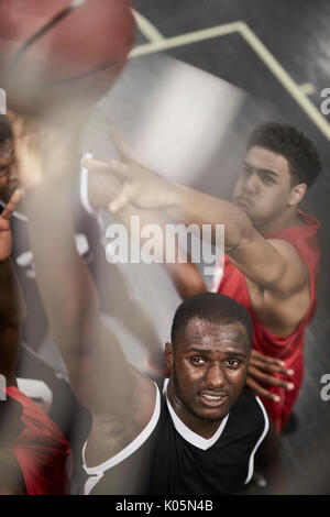 Entschlossene junge männliche Basketball player Dunking die Kugel Stockfoto