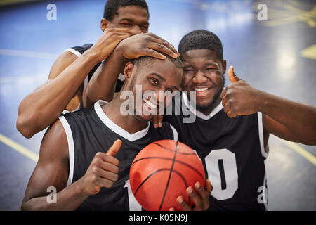 Porträt Lächeln, selbstbewusste junge männliche Basketball player Team feiern, Gestik, die Daumen-hoch Stockfoto