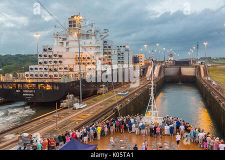 Panama Canal, Panama. Containerschiff Eingabe erste Sperre, Karibischen Seite, Richtung Lake Gatun, Passagiere auf Kreuzfahrtschiffen beobachten. Stockfoto