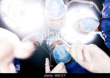 Low Angle View der Chirurgen unter Chirurgie leuchten im Operationssaal. Medizin Fachleute Durchführung der zahnärztlichen Chirurgie. Stockfoto