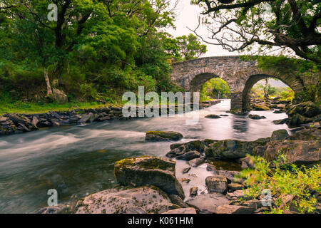 Die alte Weir Bridge ist eine alte Brücke im Nationalpark Killarney im County Kerry, Irland entfernt. Es ist eine Bogenbrücke aus Stein. Die Brid Stockfoto