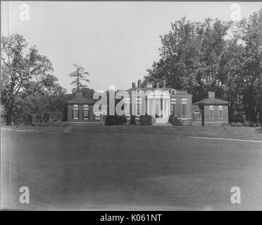 Landschaft geschossen eines Gebäudes mit Parthenon Säulen und ein Fries mit Blättern von Bäumen umgeben, eine große Leere Rasenfläche vor dem Gebäude, Roland Park/Boston, USA, 1910. Dieses Bild wird von einer Reihe dokumentieren den Bau und den Verkauf von Wohnungen in der Roland Park/Guilford Nachbarschaft von Baltimore, einer Straßenbahn Vorort und eines der ersten geplanten Gemeinschaften in den Vereinigten Staaten. Stockfoto