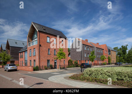Moderne Vorstadtgebäude mit Bäumen entlang der Straße und einem landschaftlich gestalteten SUD-Gebiet rechts im Northampton-Vorort Upton, England. Stockfoto