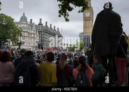 London, Großbritannien, 21. August 2017: Menschenmassen versammeln, die von der Statue von Mahatma Gandhi im Parlament Platz zu hören die letzten Glockenspiel von Big Ben, die riesige Glocke in Elizabeth Tower, dass die Ringe in London, bevor er seinen umstrittenen Silencing, außer zu besonderen Anlässen, durch die Reparatur Projekt, das voraussichtlich 2021 abgeschlossen sein. Foto von Richard Baker/Alamy Leben Nachrichten. Stockfoto