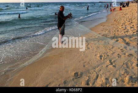 August 21, 2017 - Gaza, Gazastreifen, Palästinensische Autonomiegebiete - Palästinensische fischer Jihad al-Soltan bereitet seine Fischernetz an einem Strand im nördlichen Gazastreifen August 21, 2017 (Bild: © YASSER Qudih/APA Bilder über ZUMA Draht) Stockfoto