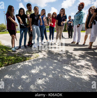 Boynton Beach, Florida, USA. 21 Aug, 2017. Christa McAuliffe Middle School Science teacher Jennifer Hamilton weist auf die sichelförmige Schatten durch die Eclipse wie die Sonne gebildet durch am Baum auf dem Campus in Boynton Beach, Florida, am 21. August 2017 glänzt. Credit: Allen Eyestone/der Palm Beach Post/ZUMA Draht/Alamy leben Nachrichten Stockfoto