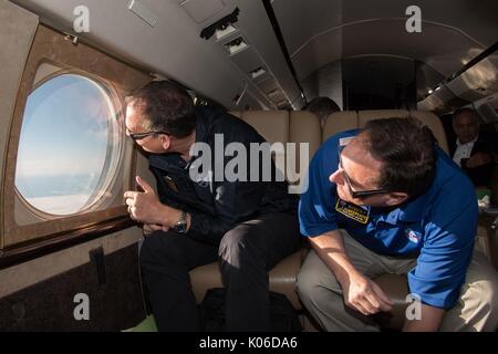 Die NASA-Administrator Robert Lightfoot, rechts, und NASA-Administrator Associate für die Science Mission Directorate Thomas Zurbuchen um die Sonnenfinsternis von an Bord eines NASA Armstrong Flug Forschungsstelle Gulfstream III August 21, 2017 Flying 35.000 Fuß über der Küste von Oregon. Die totale Sonnenfinsternis über einem schmalen Teil des angrenzenden Vereinigten Staaten von Oregon nach South Carolina und eine partielle Sonnenfinsternis war über den gesamten nordamerikanischen Kontinent sichtbar zusammen mit Teilen von Südamerika, Afrika und Europa. Stockfoto