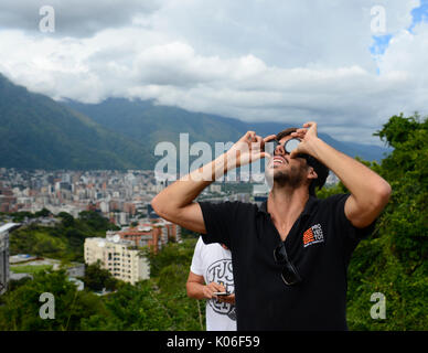 Caracas, Venezuela. 21 Aug, 2017. Ein Mann sieht der Himmel durch spezielle Gläser während einer Sonnenfinsternis in Caracas, Venezuela, 21. August 2017. Foto: Manaure Quintero/dpa/Alamy leben Nachrichten Stockfoto