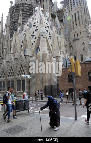 Eine alte arme Frau neben der Basilika Sagrada Familia in Barcelona. Stockfoto