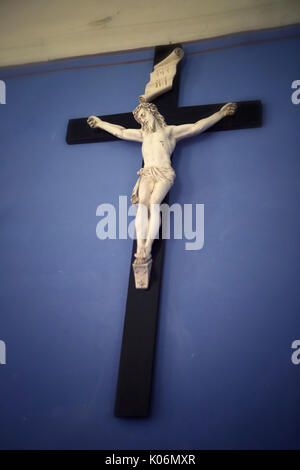 Hölzerne Kreuz mit Jesus auf einer blauen Wand Stockfoto