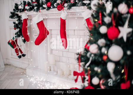 Ein Bild schließen der schön dekorierten hellen roten Weihnachten Socken hängen an einem Kamin warten auf präsentiert. Stockfoto