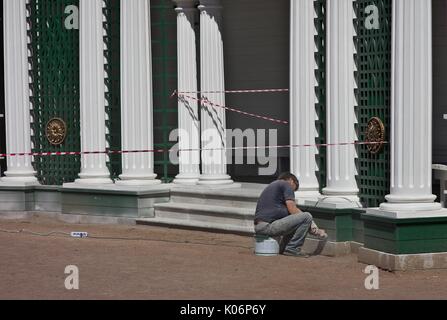 Mann mit Power Schleifer auf historischen Gebäude in Perterhof, Russland Stockfoto