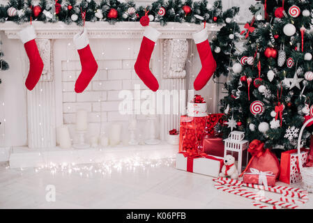 Ein Bild schließen der schön dekorierten hellen roten Weihnachten Socken hängen an einem Kamin warten auf präsentiert. Stockfoto