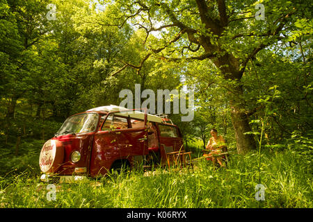 Sommer im Wye Valley: eine Frau mittleren Alters fahren Ihre klassische 1973 VW Typ 2 (T2) Erker roten Wohnmobil Urlaub entlang der malerischen Wye Valley in der Mitte von Wales an einem heißen Juli morgen. Powys Wales UK Stockfoto