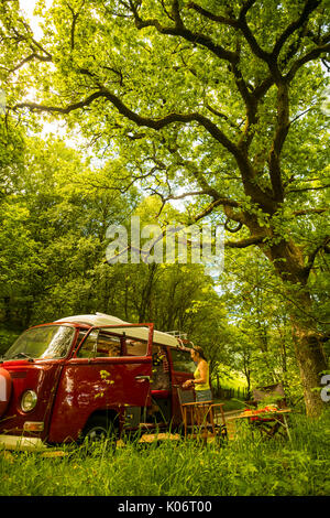 Sommer im Wye Valley: eine Frau mittleren Alters fahren Ihre klassische 1973 VW Typ 2 (T2) Erker roten Wohnmobil Urlaub entlang der malerischen Wye Valley in der Mitte von Wales an einem heißen Juli morgen. Powys Wales UK Stockfoto