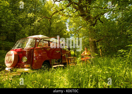 Sommer im Wye Valley: eine Frau mittleren Alters fahren Ihre klassische 1973 VW Typ 2 (T2) Erker roten Wohnmobil Urlaub entlang der malerischen Wye Valley in der Mitte von Wales an einem heißen Juli morgen. Powys Wales UK Stockfoto