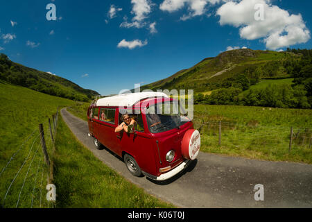 Sommer im Wye Valley: eine Frau mittleren Alters fahren Ihre klassische 1973 VW Typ 2 (T2) Erker roten Wohnmobil Urlaub entlang der malerischen Wye Valley in der Mitte von Wales an einem heißen Juli morgen. Powys Wales UK Stockfoto