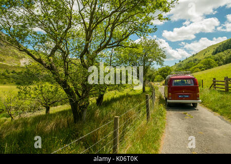 Sommer im Wye Valley: eine Frau mittleren Alters fahren Ihre klassische 1973 VW Typ 2 (T2) Erker roten Wohnmobil Urlaub entlang der malerischen Wye Valley in der Mitte von Wales an einem heißen Juli morgen. Powys Wales UK Stockfoto