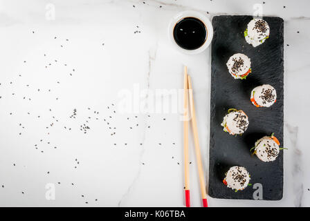 Trend hybrid Essen. Japanische asiatische Küche. Mini Sushi-Burger, Sandwiches mit Lachs, hayashi Wakame, daikon, Ingwer, roter Kaviar. Weißer Marmor tisch, Stockfoto